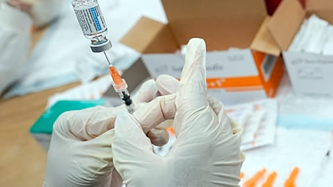 A registered nurse fills a syringe with the Johnson & Johnson COVID-19 vaccine.
