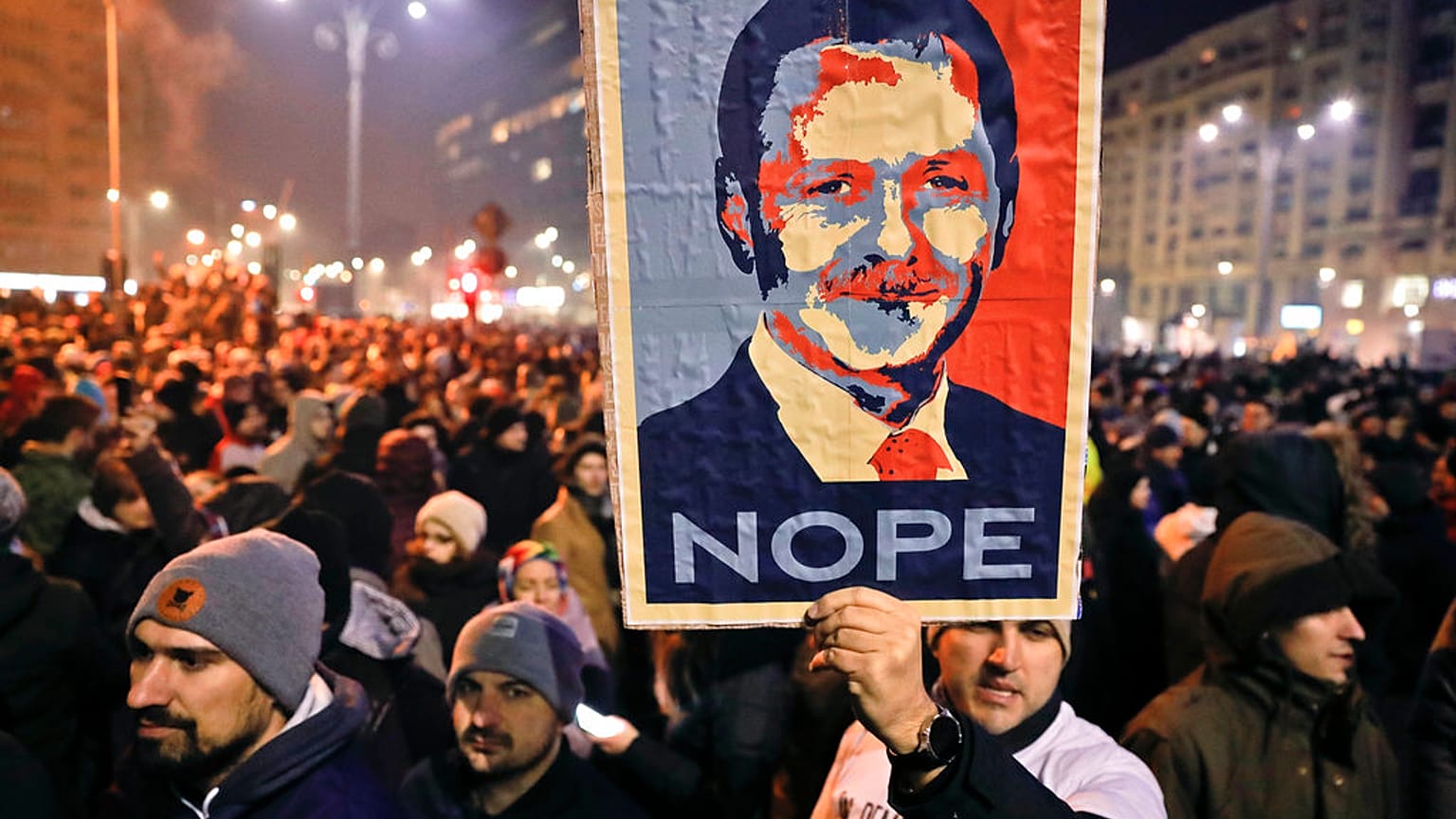 In this Tuesday, Jan. 31, 2017, file picture a man holds a poster depicting the leader of the ruling Social Democratic party Liviu Dragnea, during a protest in Bucharest.