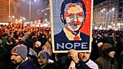 In this Tuesday, Jan. 31, 2017, file picture a man holds a poster depicting the leader of the ruling Social Democratic party Liviu Dragnea, during a protest in Bucharest.