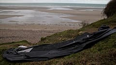 A damaged inflatable small boat is pictured on the shore in Wimereux, northern France, Thursday, 25 November 2021.