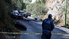 Forensic investigators work an area where a burned-out car was found after a gang rammed several vehicles into a prison and escaped with nine inmates, in Tula, Mexico.