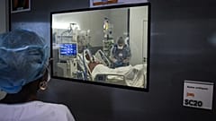 Medical staff members tend to a Covid-19 patient under respiratory assistance, in a room of the intensive care unit in Martinique.
