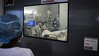 Medical staff members tend to a Covid-19 patient under respiratory assistance, in a room of the intensive care unit in Martinique.