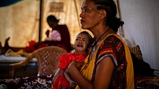 Roman Kidanemariam, 35, lányával, a 22 hónapos, súlyosan alultáplált Merkab Atakltival ellátásra várnak egy sátorban Etiópiában, a Tigray régióban