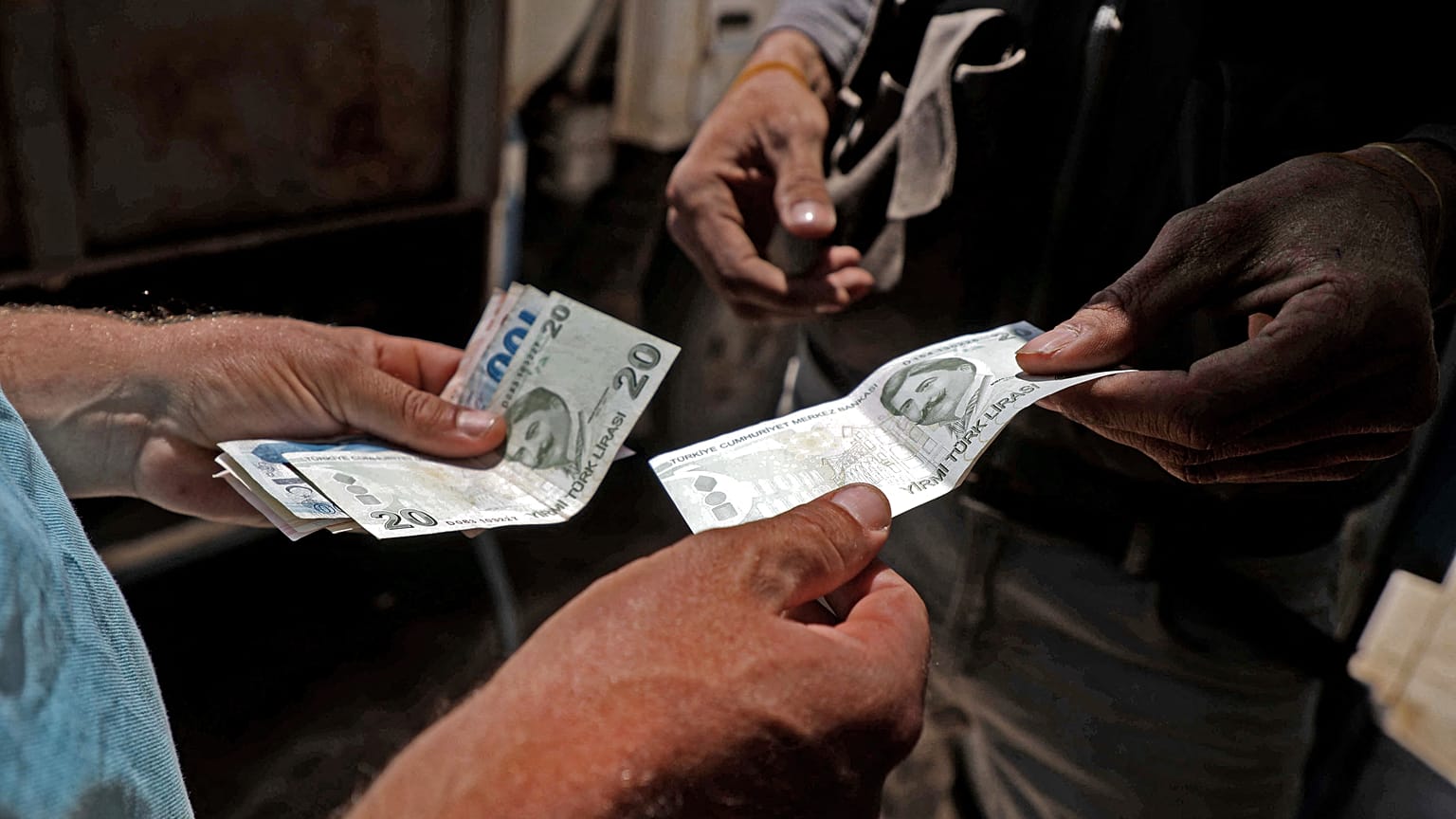 A Syrian man pays with Turkish lira at a gas station in the town of Sarmada in Syria's northwestern Idlib province, on June 15, 2020. 
