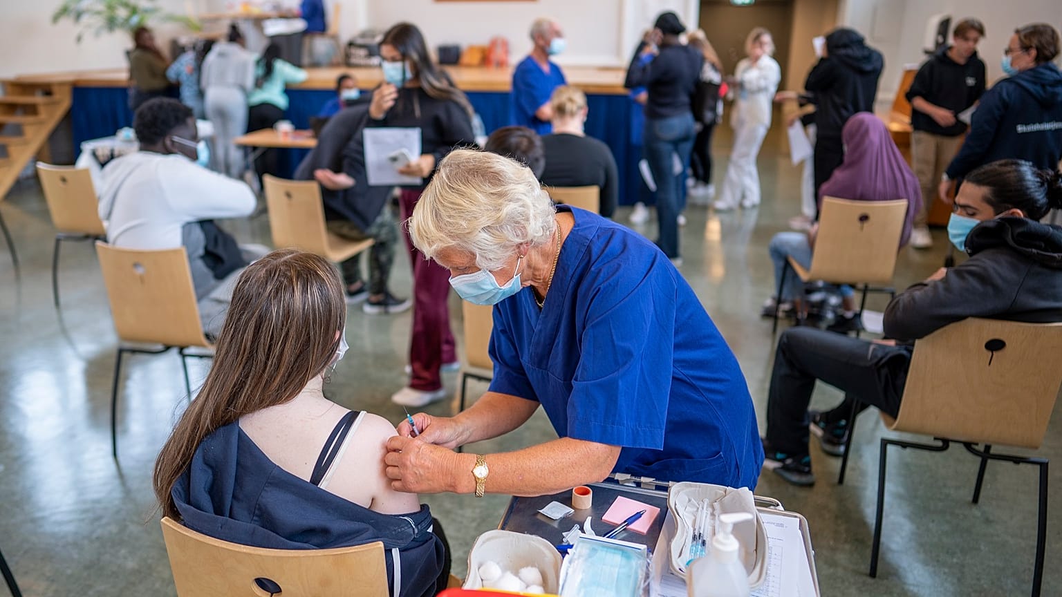 A student at Holtet high school receives the first dose of Pfizer vaccine against COVID-19 in the school's auditorium in Oslo, Sept. 7, 2021.