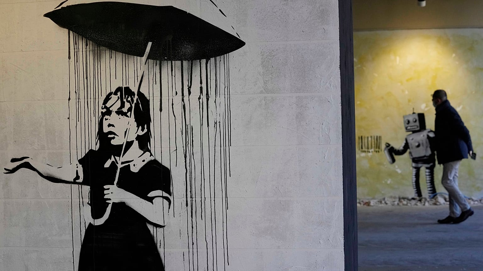 "The Umbrella girl" a reproduction of a mural by British artist Banksy is seen at an exhibition at the Milano Centrale main railway station in Milan, on Dec. 2, 2021.
