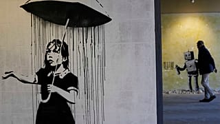 "The Umbrella girl" a reproduction of a mural by British artist Banksy is seen at an exhibition at the Milano Centrale main railway station in Milan, on Dec. 2, 2021.
