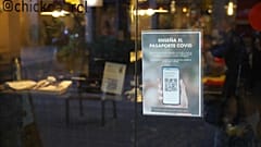 Un cartel solicitando el pasaporte covid está pegado en la puerta de un restaurante en Barcelona