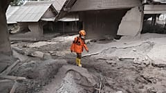 Un rescatista camina en una zona afectada por la erupción del volcán Semeru en el distrito de Lumajang, provincia de Java Oriental, Indonesia, el 5 de diciembre de 2021.