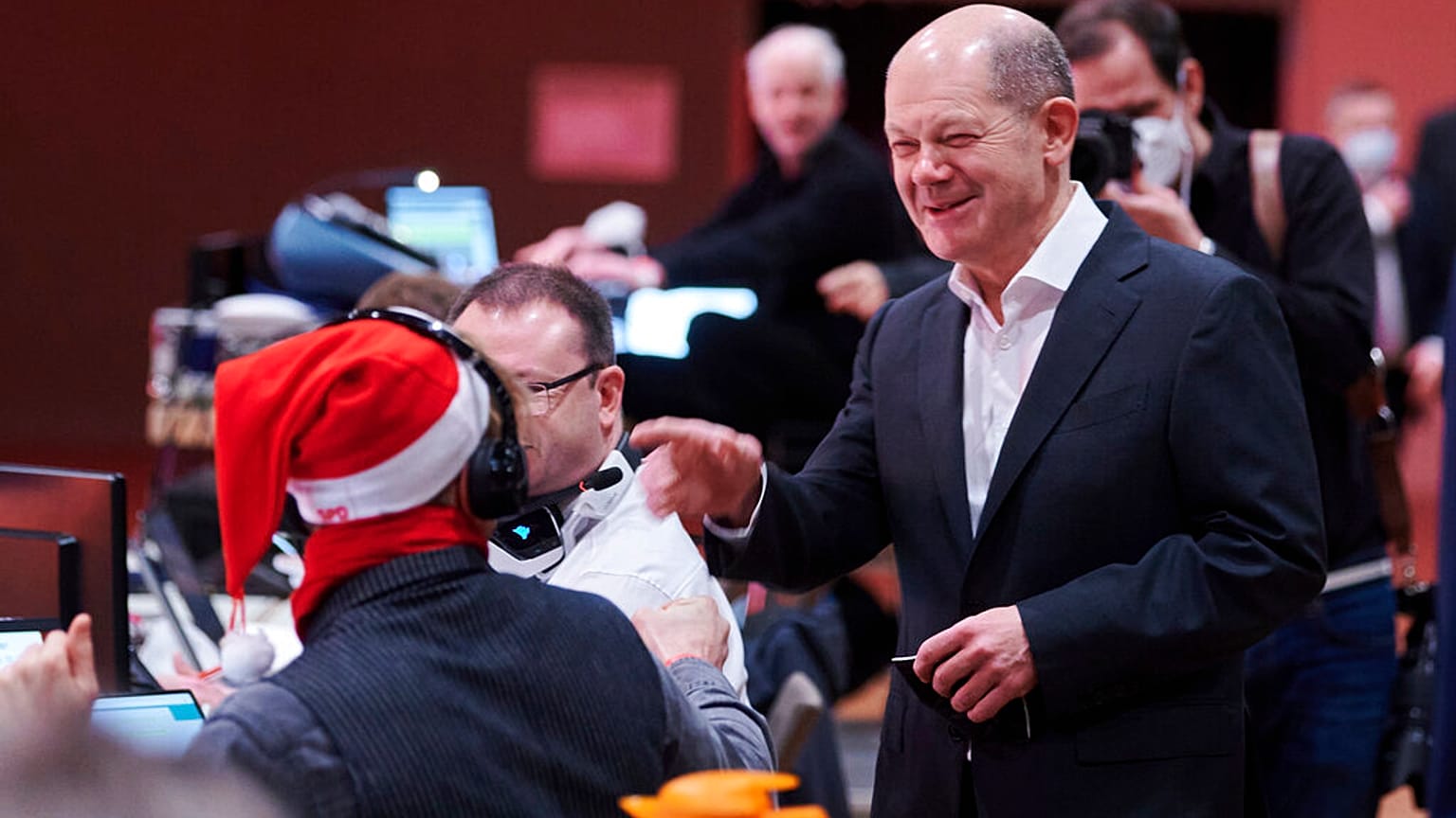 Olaf Scholz (SPD), Chancellor-designate, greets a party member wearing a Santa Claus hat at the Berlin SPD state party conference, in Berlin, Sunday, Dec. 5, 2021.
