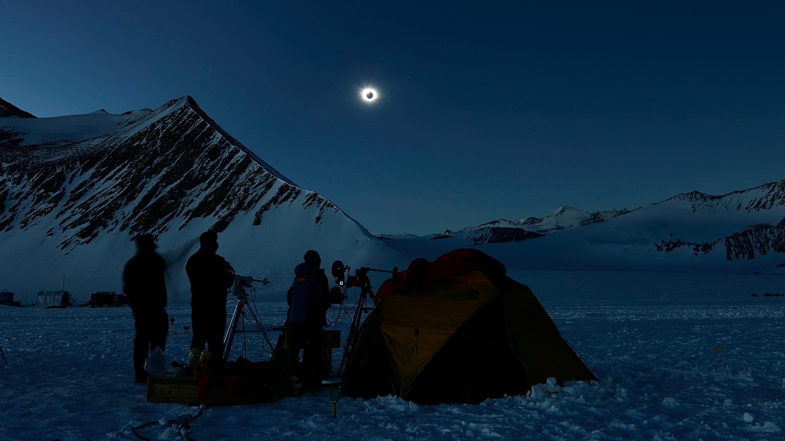 In this photo provided by Imagen de Chile, people view a total solar eclipse from Polar Union Glacier Camp in Antarctica, Saturday, Dec. 4, 2021.
