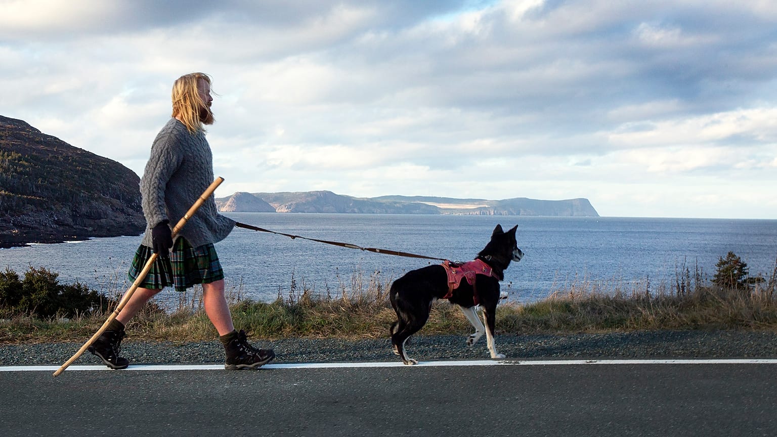 Michael Yellowlees, of Scotland, and his husky Luna walk the road to Cape Spear in Newfoundland and Labrador on Sunday, Dec. 5, 2021.