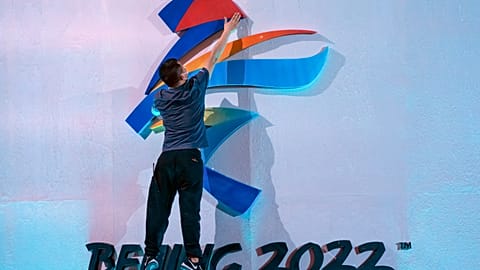 A crew member fixes a logo for the 2022 Beijing Winter Olympics before a launch ceremony.