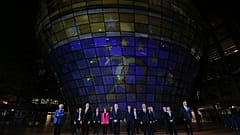 A presidente do BCE, Christine Lagarde, e os ministros das Finanças da Zona Euro em frente a um painel que assinala os 20 anos do Euro