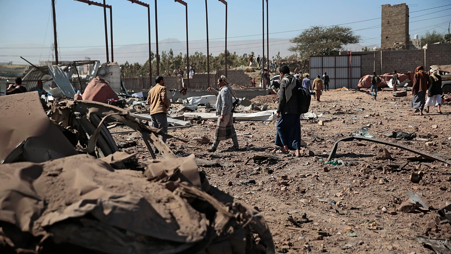 أشخاص يتفقدون موقع الغارات الجوية التي شنها التحالف بقيادة السعودية في صنعاء، اليمن. 5 ديسمبر / كانون الأول 2021.
