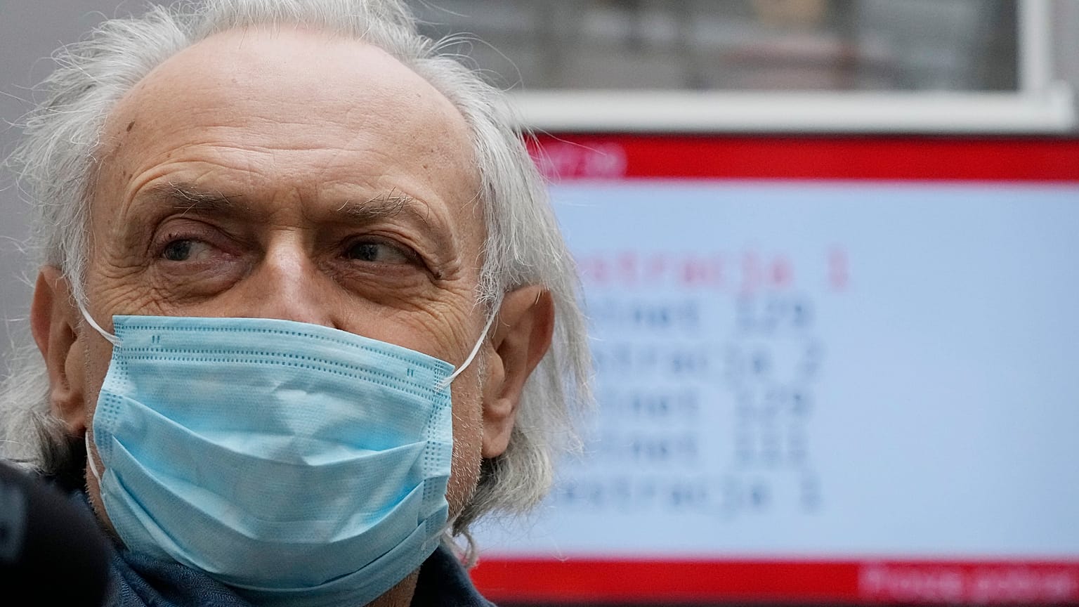 A man waits in a vaccine center after getting a shot against COVID-19 in in Warsaw, Poland, Tuesday Dec. 7, 2021. 