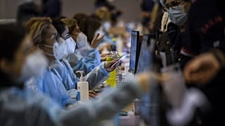 Healthcare workers register people who will receive a dose of Covid-19 vaccine, at the vaccination centre of Parque das Nacoes in Lisbon on December 1, 2021.