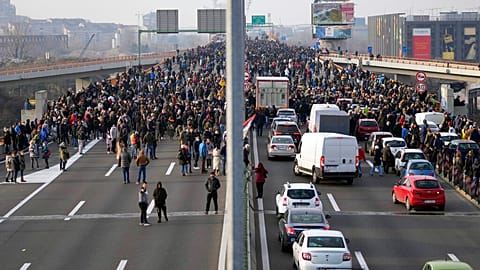 Protesters stand on the highway during a protest in Belgrade, Serbia, Saturday, Dec. 4, 2021.