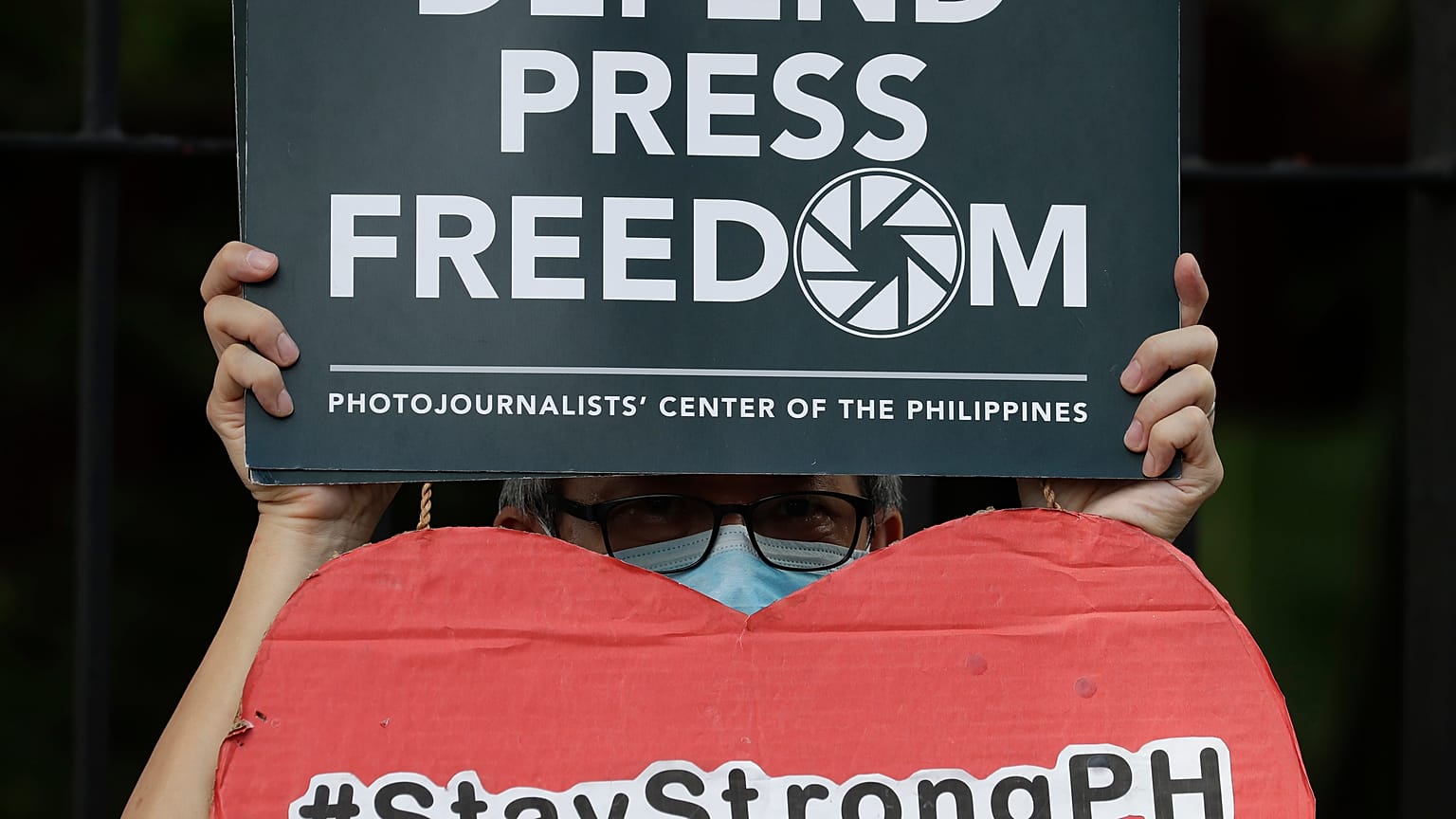 An employee of the country's largest TV network ABS-CBN, holds a slogan during a rally outside the House of Representatives in Manila, Philippines, July 9, 2020.