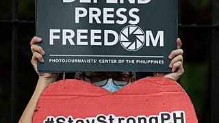 An employee of the country's largest TV network ABS-CBN, holds a slogan during a rally outside the House of Representatives in Manila, Philippines, July 9, 2020.