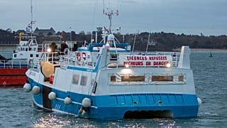 A banner reading "licenses refused. Fishermen in danger" is set on a French fishing boat during a blockage of the entrance to the port of Saint-Malo, France, Nov. 26, 2021.