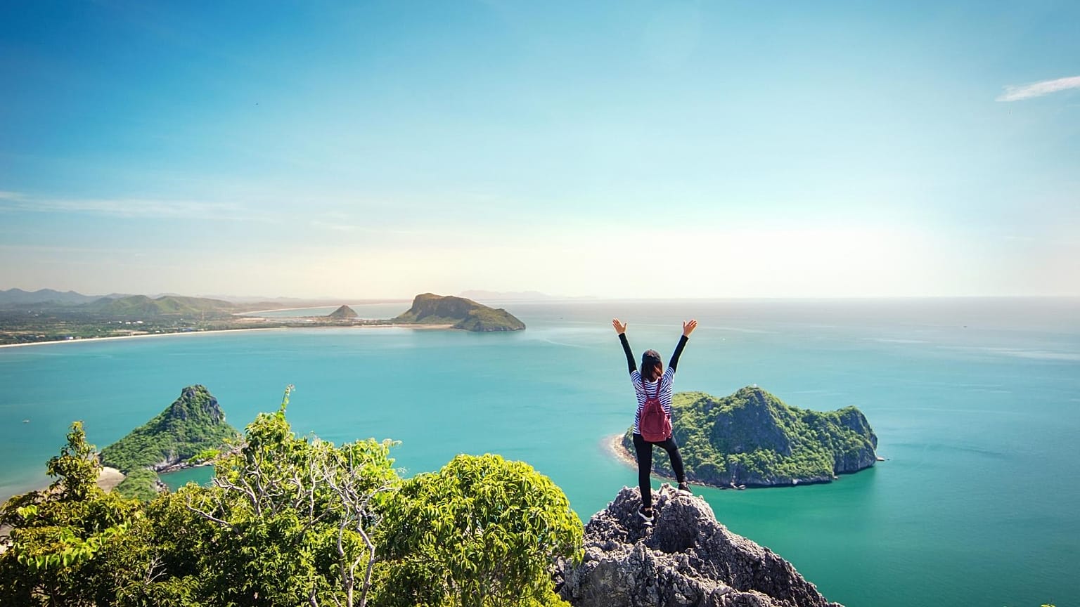 A woman stands on a cliff