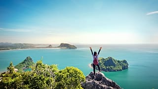 A woman stands on a cliff