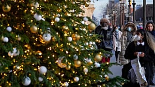 Des personnes masquées regardant les décorations de Noël dans les rues de Paris