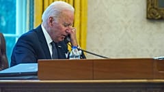 In this image made through a window, President Joe Biden talks on the phone with Ukrainian President Volodymyr Zelenskyy from the Oval Office