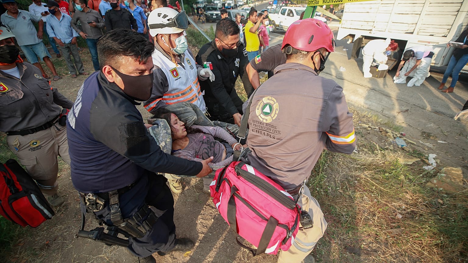 An injured migrant woman is moved by rescue personnel from the site of an accident near Tuxtla Gutierrez, Chiapas state, Mexico, Dec. 9, 2021.