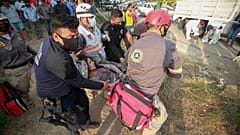 An injured migrant woman is moved by rescue personnel from the site of an accident near Tuxtla Gutierrez, Chiapas state, Mexico, Dec. 9, 2021