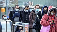 Commuters wearing face masks to protect against COVID-19 ride an escalator at La Defense business district in Paris on Wednesday, December 8