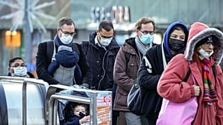 Commuters wearing face masks to protect against COVID-19 ride an escalator at La Defense business district in Paris on Wednesday, December 8