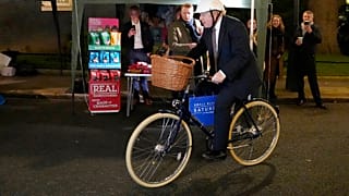 El primer ministro británico, Boris Johnson, monta en bicicleta mientras asiste a un mercado de alimentos y bebidas del Reino Unido instalado en Downing Street, en Londres