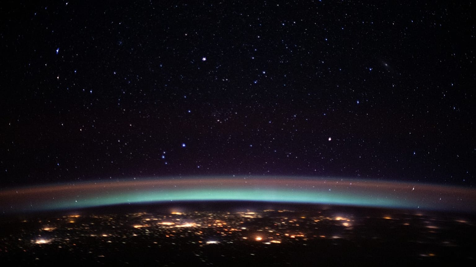 This NASA image obtained March 24, 2020 shows the city lights at the intersection of Europe and Asia as they sparkle underneath an atmospheric glow and a starry night sky.