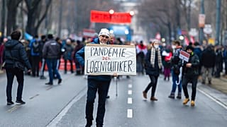 Un manifestant tenant une pancarte lors de la mobilisation contre les restrictions sanitaires, Vienne, Autriche, le 11 décembre 2021