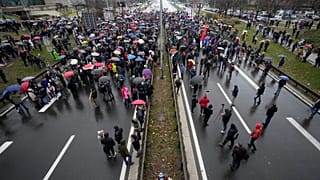 Protesters stand on the highway during a protest in Belgrade, Serbia, Saturday, Dec. 11, 2021.