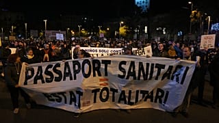 Demonstrators hold a banner reading "health passport, totalitarian state", during a demonstration against the Covid-19 health pass in Barcelona, 11 December 2021.