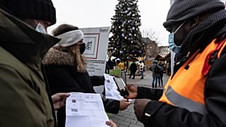 Security personnel check a COVID-19 health pass to access a Christmas market in Strasbourg, eastern France, Dec 3, 2021. 