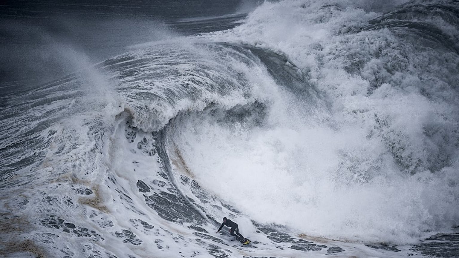 Ein Surfer vor Praia do Norte in Nazaré am 11.12.2021.