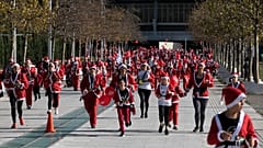 People wearing Santa Claus costumes take part in the Athens Santa Run, in Athens, Sunday, Dec. 12, 2021. 