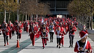 People wearing Santa Claus costumes take part in the Athens Santa Run, in Athens, Sunday, Dec. 12, 2021.
