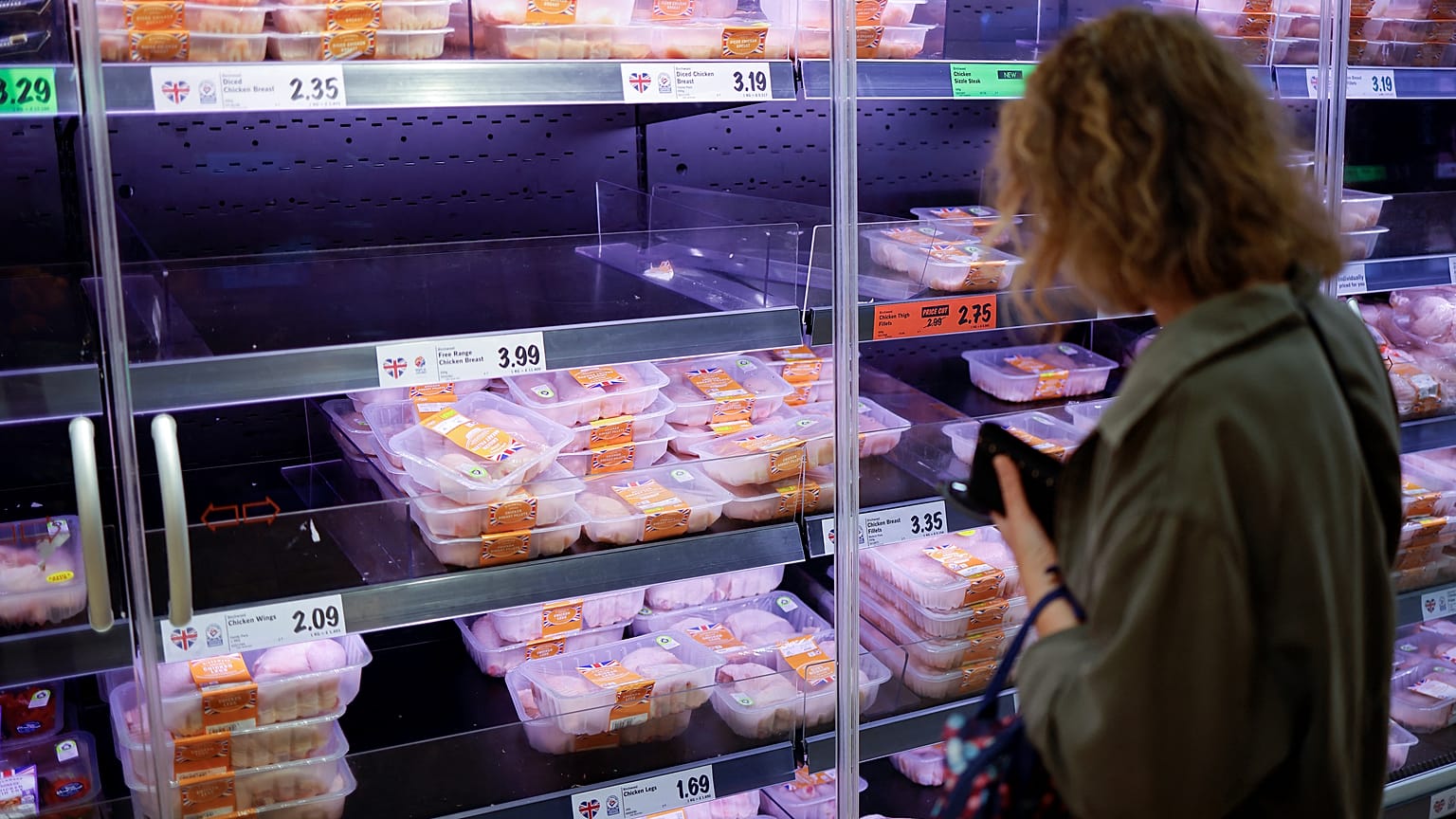 Kundin vor einem Kühlregal mit Geflügelfleisch