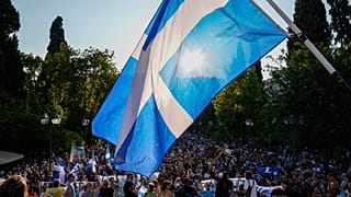 Anti-vaccine protester hold Greek flags during demonstration at Syntagma square, central Athens in July.