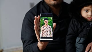 Zana Mamand, shows a photo of his missing brother, Twana Mamand, who was lost at sea in the English Channel trying to get to the UK, in Ranya, Iraq, Tuesday, Nov. 30, 2021.