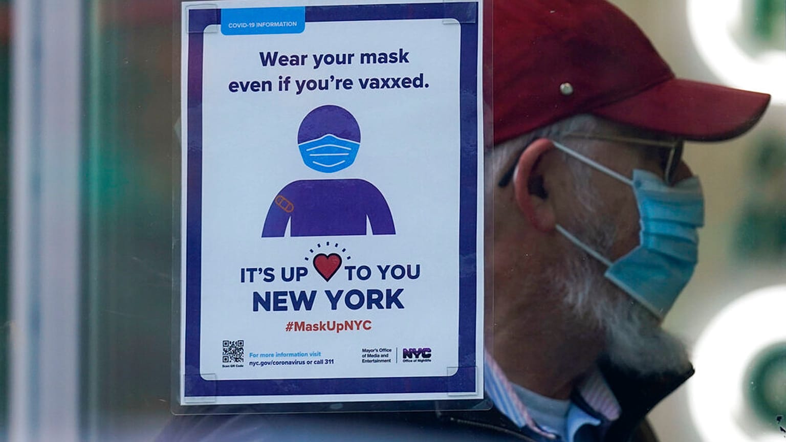 Un letrero recuerda a los viandantes que tienen que usar mascarilla en una tienda de Nueva York