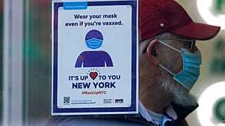 Un letrero recuerda a los viandantes que tienen que usar mascarilla en una tienda de Nueva York