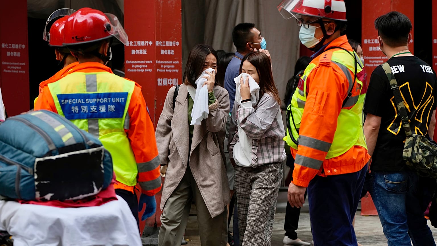 People walk out from the World Trade Centre where is located in the city's popular Causeway Bay shopping district of Hong Kong, Wednesday, Dec. 15, 2021.