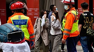 People walk out from the World Trade Centre where is located in the city's popular Causeway Bay shopping district of Hong Kong, Wednesday, Dec. 15, 2021.
